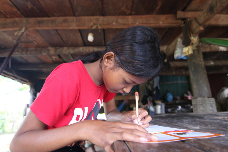 Une petite fille parrainée écrit une lettre à son parrain au Cambodge - World Vision