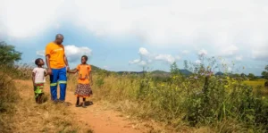 un homme marche en tenant la main de deux jeunes filles.